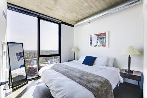 a bedroom with two beds and large windows at 2BR Designer Loft Modern Luxe in City Center in Chicago