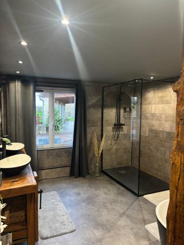 a bathroom with two sinks and a shower at Villa la Hulotte in Angles
