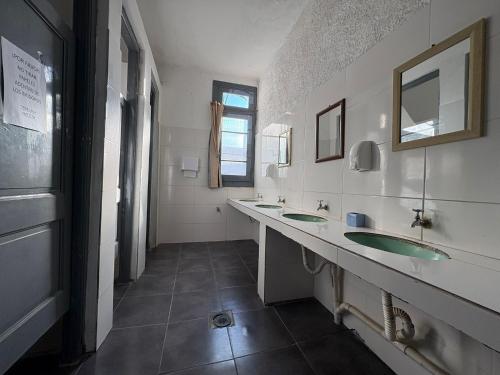 a bathroom with two sinks and two mirrors at Piriápolis Hostel & suites in Piriápolis