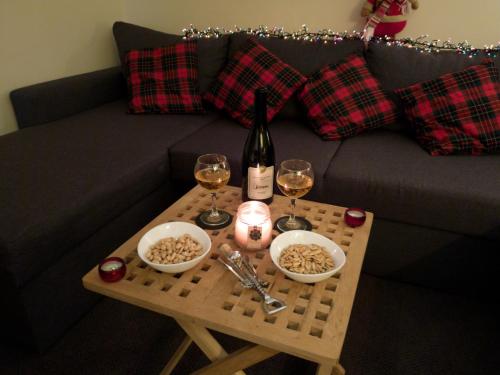 a table with two glasses of wine and a wine bottle at New Gudauri GoodHost Apartments in Gudauri