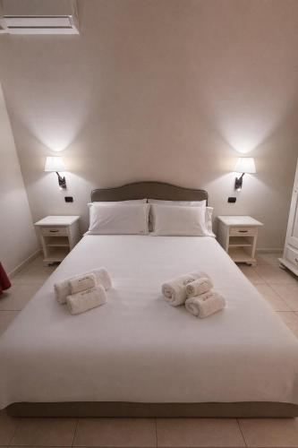 a bedroom with a white bed with towels on it at B&B Sud Est in Carmiano