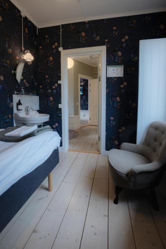 a bedroom with a bed and a sink and a chair at Tre Små Rum i Trosa in Trosa