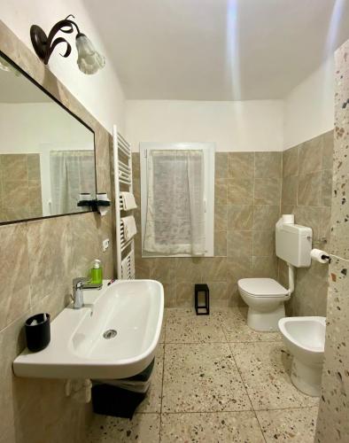 a bathroom with a sink and a toilet and a mirror at Locanda Al Cavaliere in Molinella