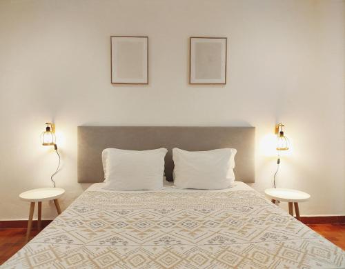 a bedroom with a large bed with two tables at Casa do Portinho - Sea View House - in São Roque