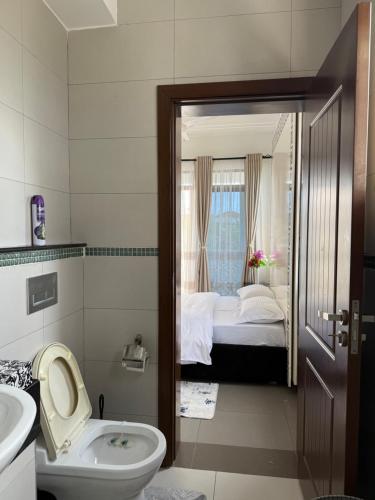 ein Badezimmer mit Toilette, Waschbecken und Bett in der Unterkunft Etheria Haven in Mombasa