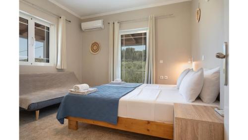 a bedroom with a large bed and a window at Ruvelis private pool villa in Fiolítis