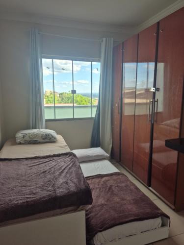 a bedroom with two beds and a large window at Casa Central Super Conforto 78 in Ponta Grossa