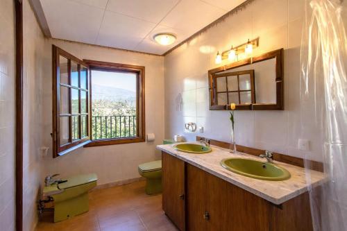 a bathroom with two sinks and a toilet and a window at Catalunya Casas Nature and Tranquility for 24 pax - 30km to beach in Sant Pere de Vilamajor