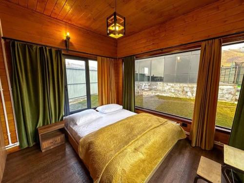 a bedroom with a bed and a large window at Chopan Resort Aparan in Aparan