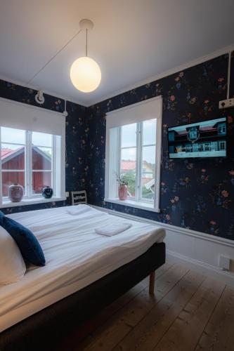 a bedroom with a large bed and two windows at Tre Små Rum i Trosa in Trosa
