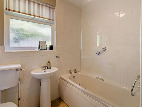 a white bathroom with a sink and a tub and a toilet at 3 Bed in Carnforth oc-sz425 in Arnside