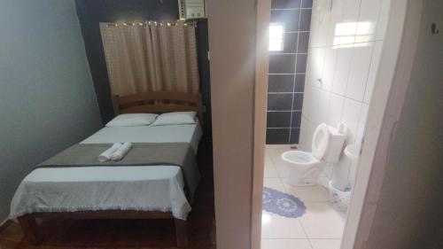 a small bedroom with a bed and a toilet at Pousada Cactos in Chapada dos Guimarães