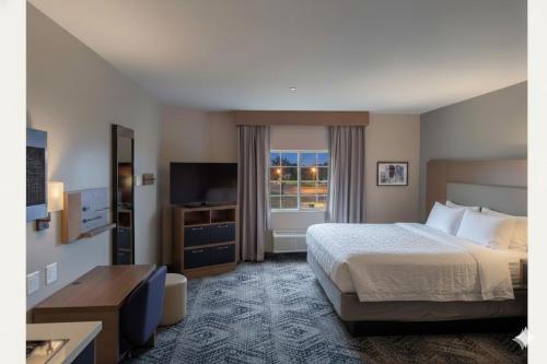 a hotel room with a bed and a television at Candlewood Suites Avondale-New Orleans by IHG in Avondale