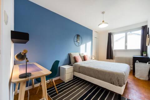 a bedroom with a blue wall with a bed and a desk at VILLA CITY GARDEN - Maison Spacieuse et Jardin - Proche Centre ville in Cholet