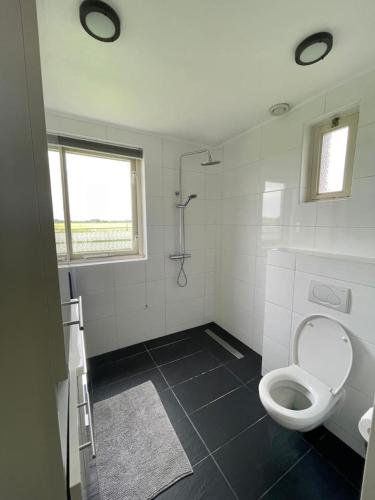 a white bathroom with a toilet and a shower at 6 - Persons Forest 223 Bungalow in Ewijk
