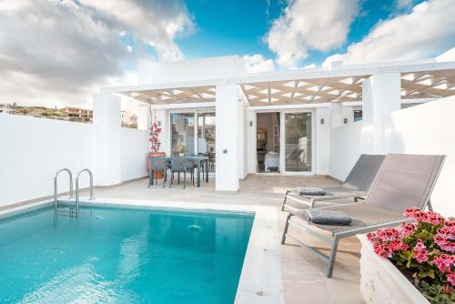 a villa with a swimming pool and a patio at Punta Mare Villas in Karpathos