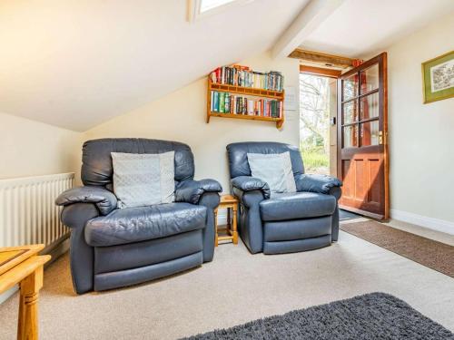 a living room with two chairs and a book shelf at 1 Bed in Penrith oc-sz295 in Dockray
