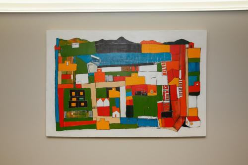 a painting of a city on a white wall at Quest Petone in Lower Hutt