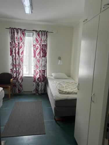 a small bedroom with a bed and a window at Huså byskola in Järpen