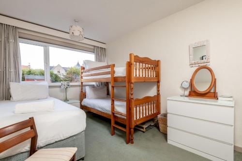 a bedroom with two bunk beds and a mirror at East Vows - Elie in Earlsferry