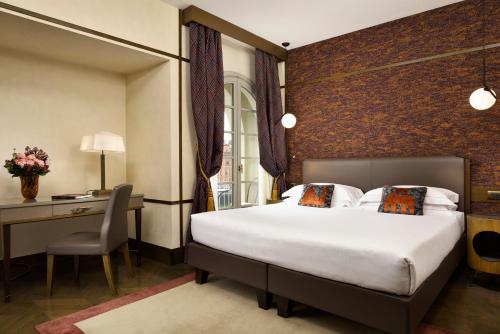 a hotel room with a bed and a desk at Hotel Balestri - WTB Hotels in Florence