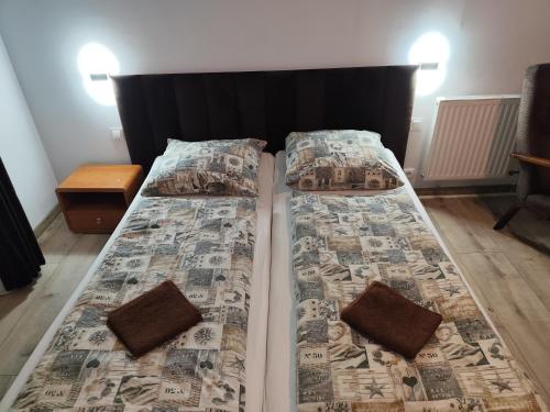a bed with two pillows and a comforter at Zajazd Kadar in Wisła
