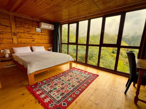 a bedroom with a bed and a large window at Gentry House in Ambrolauri