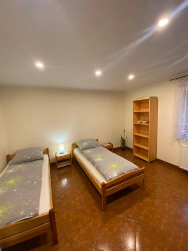 a bedroom with two beds and a book shelf at Mirenka in Czerna