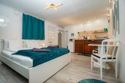 a bedroom with a large bed and a kitchen at Royal Gold Apartman in Kiskunhalas