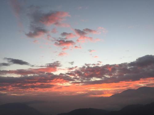 a cloudy sky with mountains in the background at Cingjing Four Seasons B&B in Renai