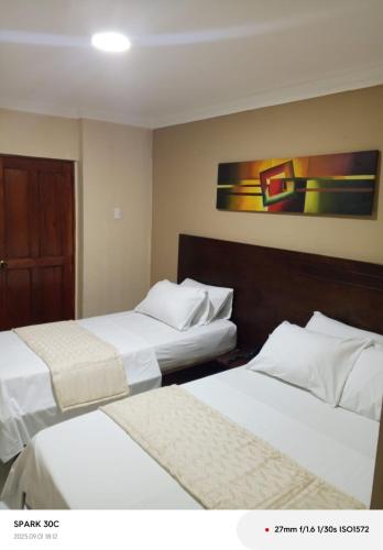 a hotel room with two beds and a painting on the wall at Hotel Paseo Colon in Barranquilla