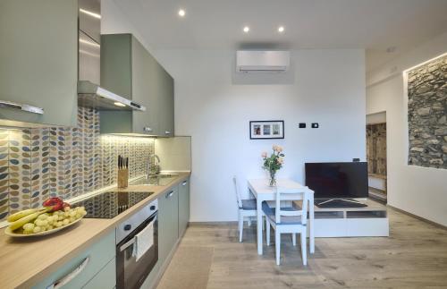 a kitchen with a table and a white table and chairs at La cà del Pin in Lierna