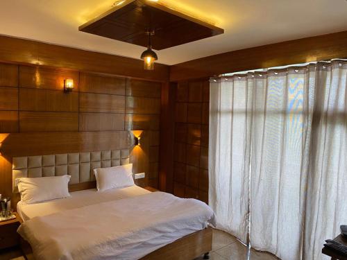 a bedroom with a large bed and a window at Hotel Mountain Nest in Nārkanda