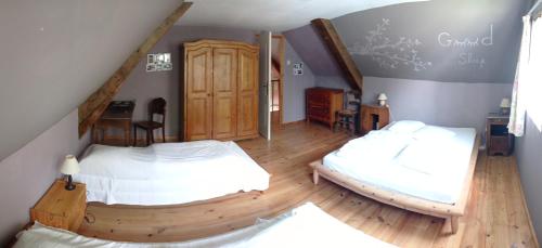a bedroom with two beds and a staircase at Gîte de la Gagée in Besmont