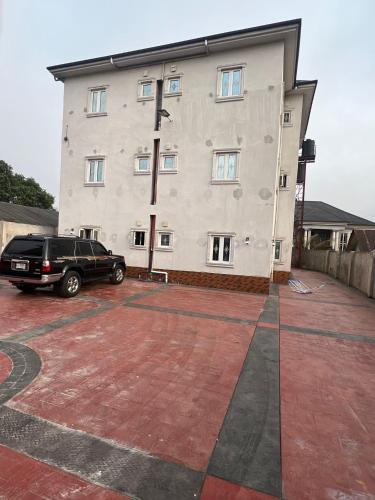 a car parked in front of a large building at Otijoe Premier Hotel 2 in Port Harcourt