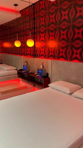 a bedroom with two beds and a red wall at Luxu's Motel in Tucano