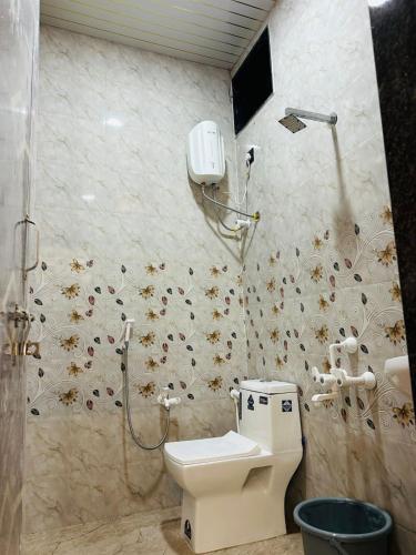 a bathroom with a toilet and a shower stall at Shiv Guest house in Ellora