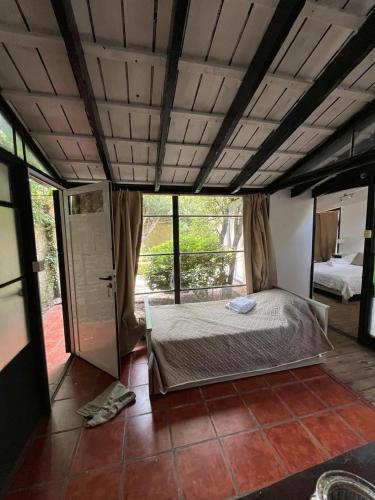 a bedroom with a bed in a room with windows at La Huella in Chascomús