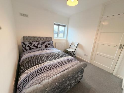 a bedroom with a large bed and a chair at Precious House 5 in Leicester