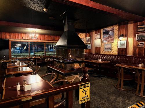 a restaurant with wooden tables and chairs in a room at Airport Chalet in Whitehorse
