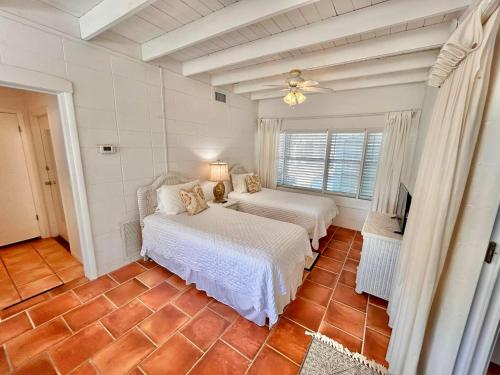 a bedroom with two beds and a television in it at Barefoot Beach Bungalow-Ground Level-3BR in St. George Island