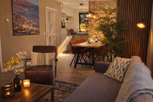 a living room with a couch and a table at Gezellig 6pers Familiehuis grote tuin met BBQ aan meer Gelderland in Ewijk