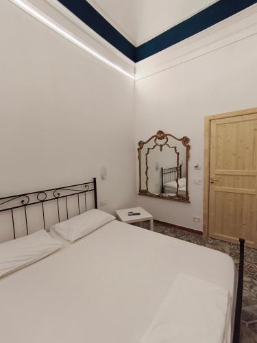 a bedroom with a bed and a mirror at casa Giuseppe in Catania