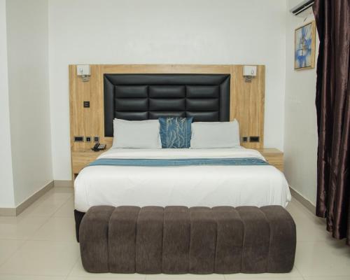 a large bed with a large headboard in a bedroom at Golden Tulip Hotel in Asaba