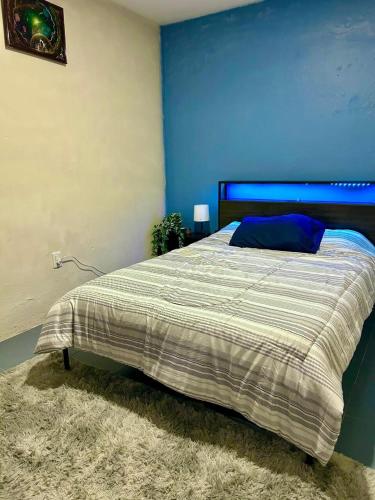a bedroom with a bed with a blue wall at Cómodo departamento en zona céntrica de Puebla in San Baltasar