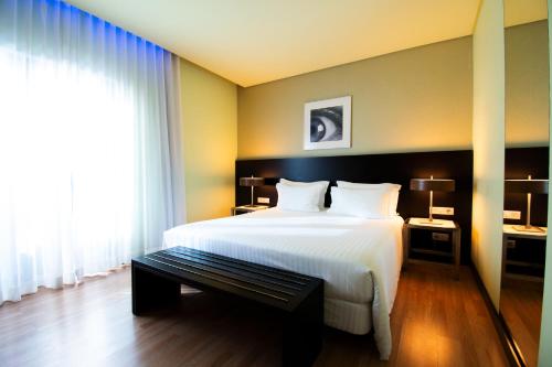 a bedroom with a large white bed and a window at SANA Capitol Hotel in Lisbon
