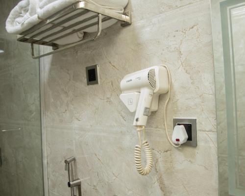 a hairdryer hanging on a wall in a bathroom at Golden Tulip Hotel in Asaba