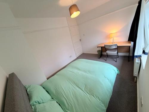 a room with a bed and a desk and a table at Precious House 3 in Leicester