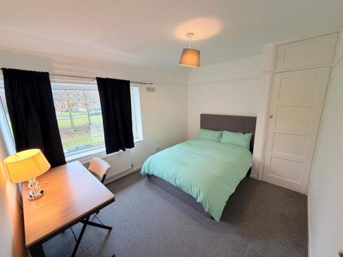 a bedroom with a bed and a desk and a table at Precious House 3 in Leicester