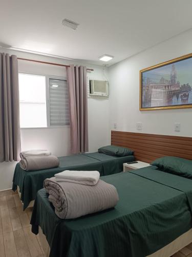 a hospital room with three beds and a window at Hotel Connect Ibira Servidor Park in São Paulo